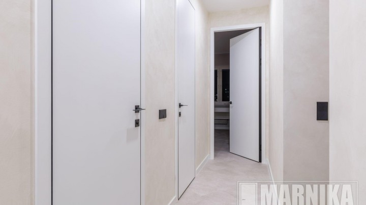 Высокие межкомнатные двери в эмали с узким наличником и входная дверь с акцентной фальш-панелью