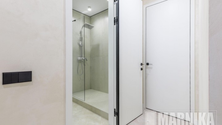 Высокие межкомнатные двери в эмали с узким наличником и входная дверь с акцентной фальш-панелью