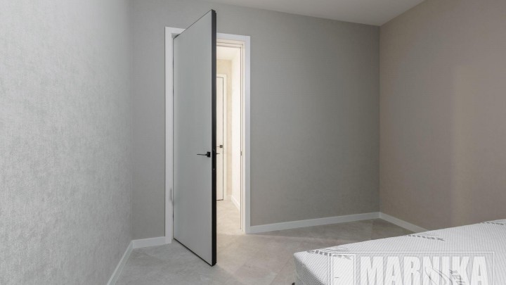 Высокие межкомнатные двери в эмали с узким наличником и входная дверь с акцентной фальш-панелью