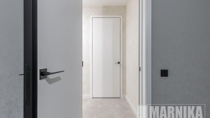 Высокие межкомнатные двери в эмали с узким наличником и входная дверь с акцентной фальш-панелью