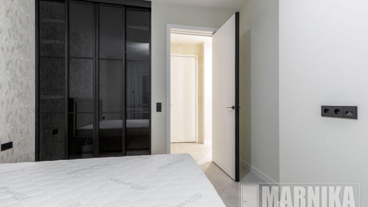 Высокие межкомнатные двери в эмали с узким наличником и входная дверь с акцентной фальш-панелью