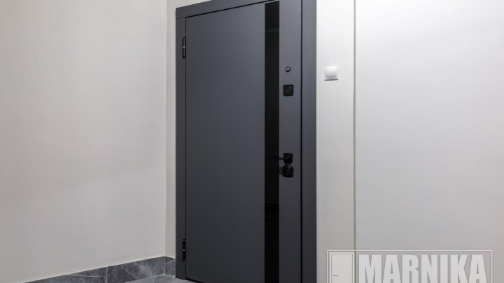 Высокие межкомнатные двери в эмали с узким наличником и входная дверь с акцентной фальш-панелью